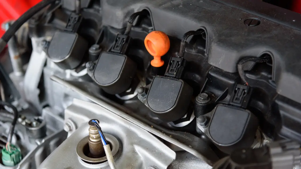 Close-up of ignition coils and engine components for a starter motor repair.