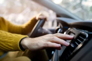 Driver adjusting car AC vents during air conditioning repair service in Dubai